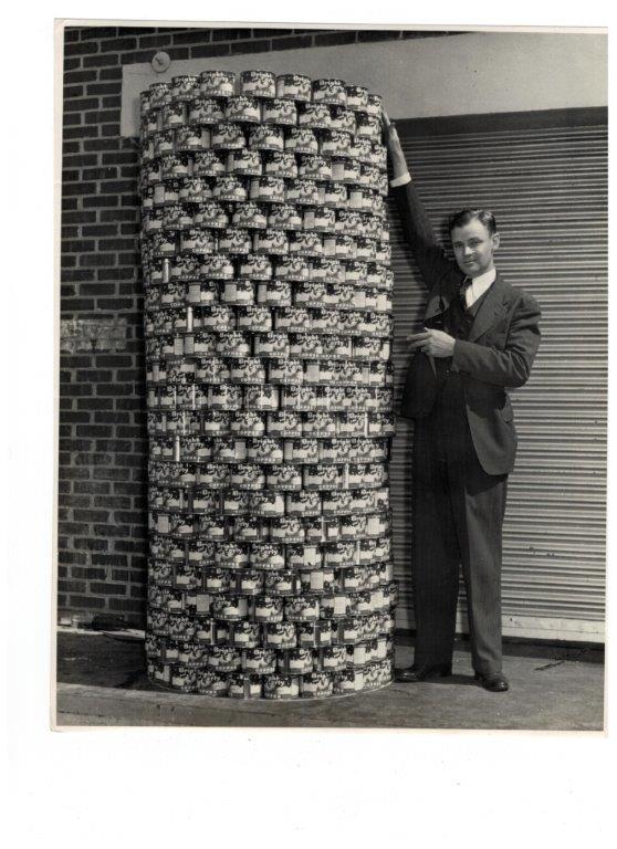 stack of Bright and Early coffee cans infront of HEB n the 1950s